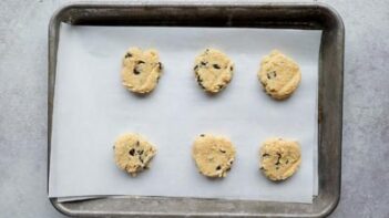 six slices of cookie dough on a baking tray