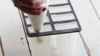 piping yogurt mixture into a popsicle mold