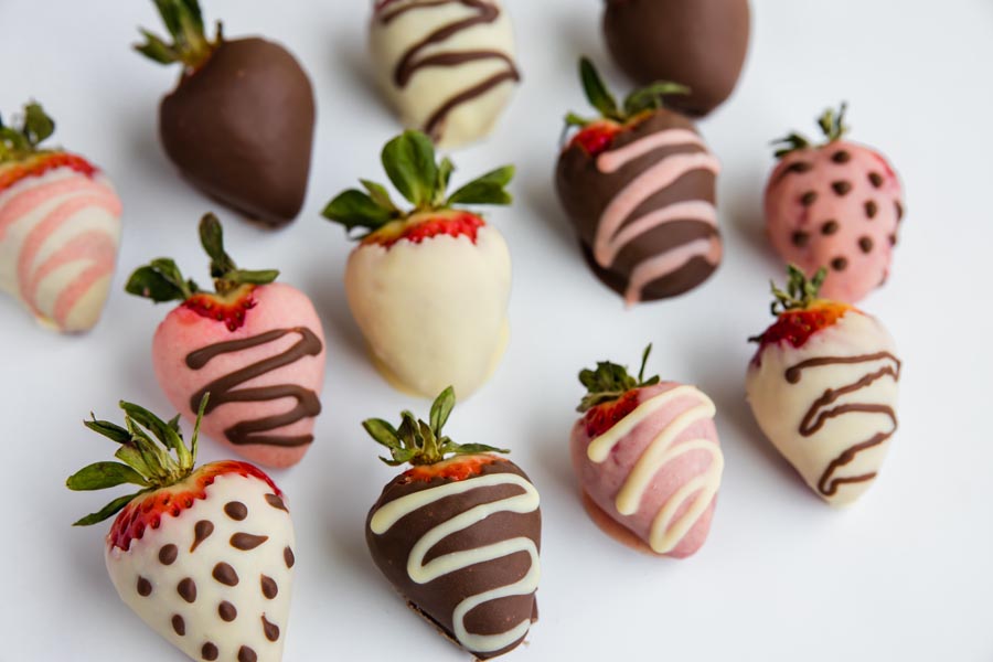 a bunch of colored sugar free chocolate covered strawberries decorated