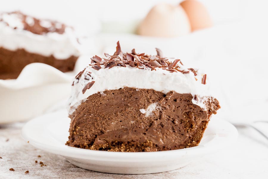 cream pie with chocolate filling topped with whipped cream and chocolate shavings