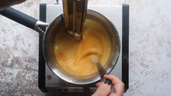 taking the temperature of an egg custard in a sauce pan