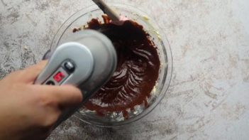 mixing chocolate batter in a bowl with an electric mixer