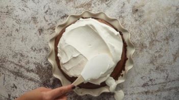 spreading whipped cream on top of a pie