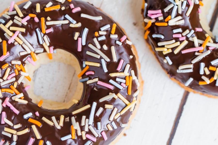 close up of a chocolate donut with colorful sprinkles