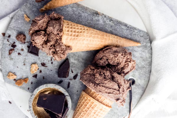 two ice cream cones with chocolate ice cream and chocolate chunks near