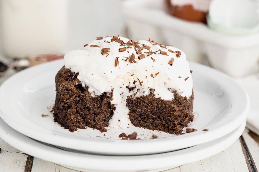 whipped cream melting down a chocolate cake