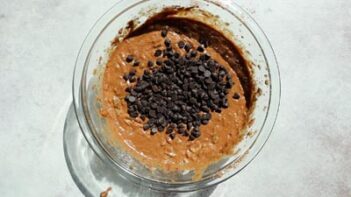 a bowl with chocolate muffin batter and chocolate chips on top