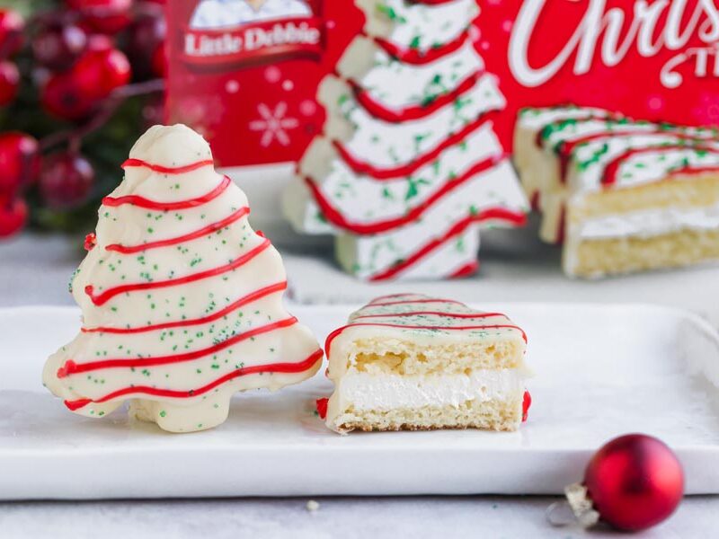 Keto Christmas tree snack cake cut open to show cream filling, with a Little Debbie box behind.