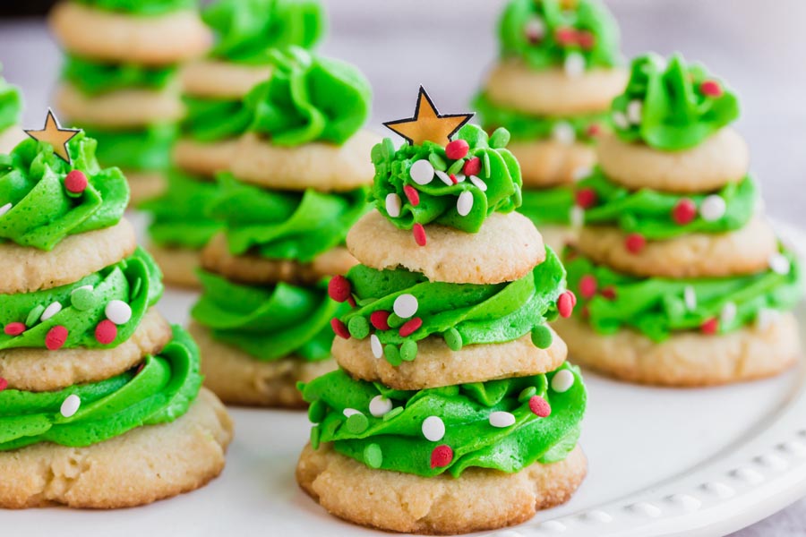 A bunch of Christmas tree cookies on a plate.