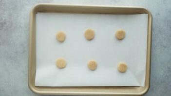 Small unbaked cookies on a small baking sheet.