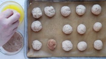 dipping doughnut holes in butter and cinnamon sugar