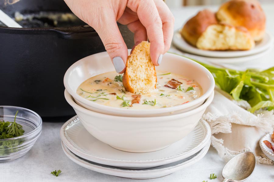 dipping a roll into the clam chowder