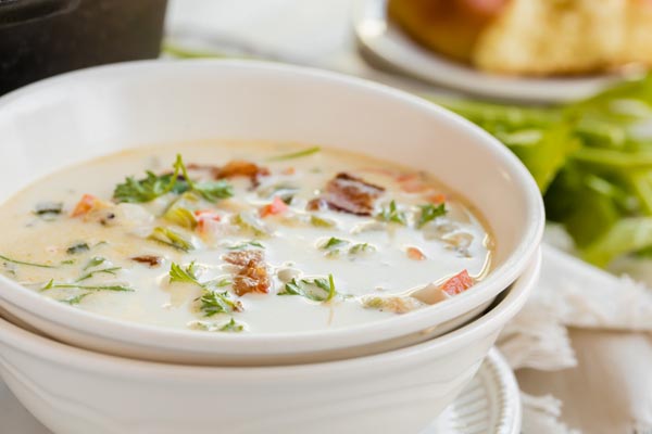 clam chowder in a bowl topped with parsley and bacon