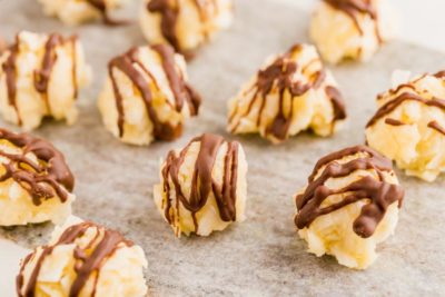 popcorn looking coconut joy candies that are drizzled with melted chocolate