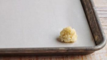 a small ball of coconut candy on a baking tray