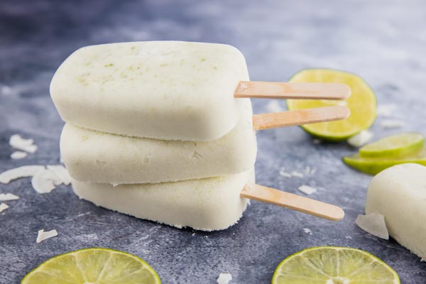 a stack of coconut lime popsicles on a blue background