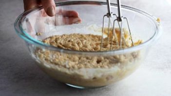 cake batter in a bowl being mixed with an electric mixer