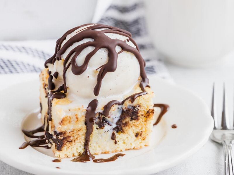 Hard chocolate magic shell on top of vanilla ice cream sitting over a square of chocolate chip cookie.