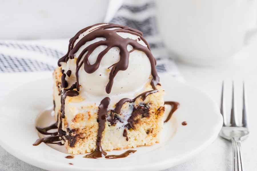 Hard chocolate magic shell on top of vanilla ice cream sitting over a square of chocolate chip cookie.