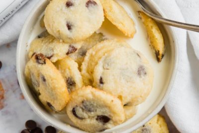 a large bowl of mini cookie cereal covered with milk and a spoon inside the bowl