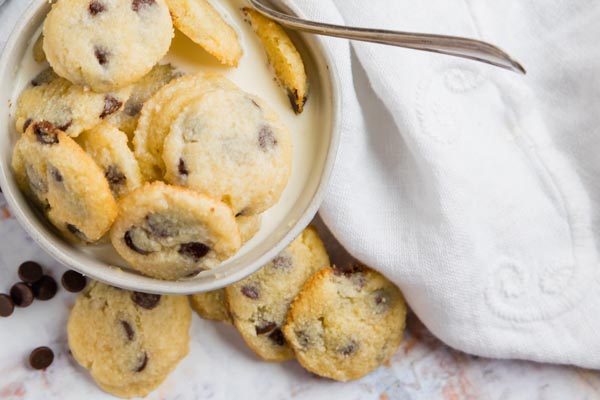 a bowl of crispy mini cookies in a small bowl with a spoon and covered with milk