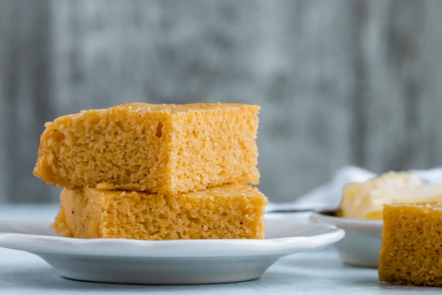 two pieces of cornbread stacked on a plate