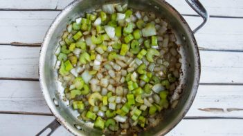 a skillet with sauteed onion and celery in it