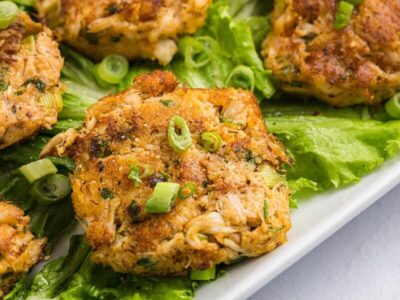 Close up of a crab cake made with fresh crab and topped with green onions.