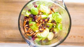 a measuring bowl with brussels sprouts pecans and cranberries
