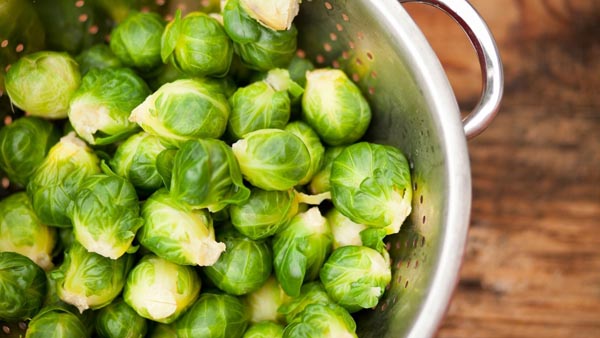 a bunch of brussels sprouts in a colander to wash