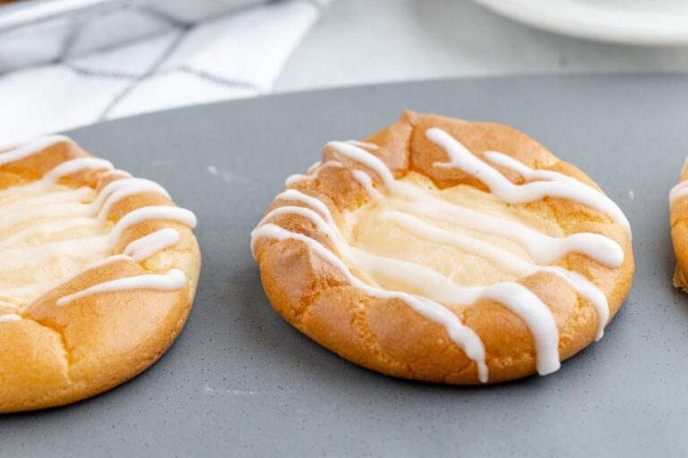danishes on a gray plate topped with white icing drizzle