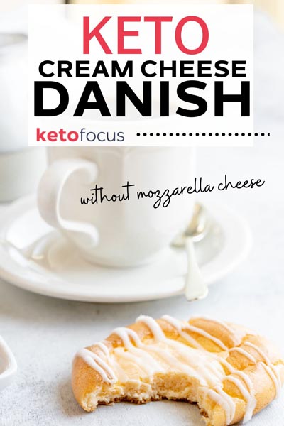 a bite out of a danish in front of a coffee cup