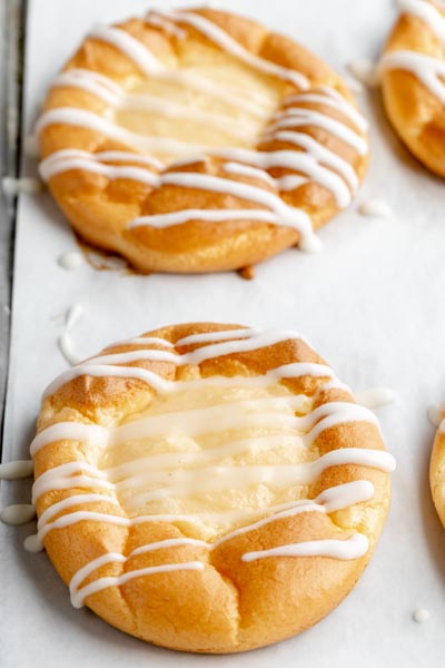 two danishes with a cream cheese filled topped with a icing drizzle