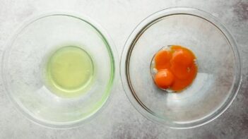 two bowls with eggs separated, one holding the whites and one with the yolks