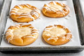 four cream cheese filled danishes on a baking tray