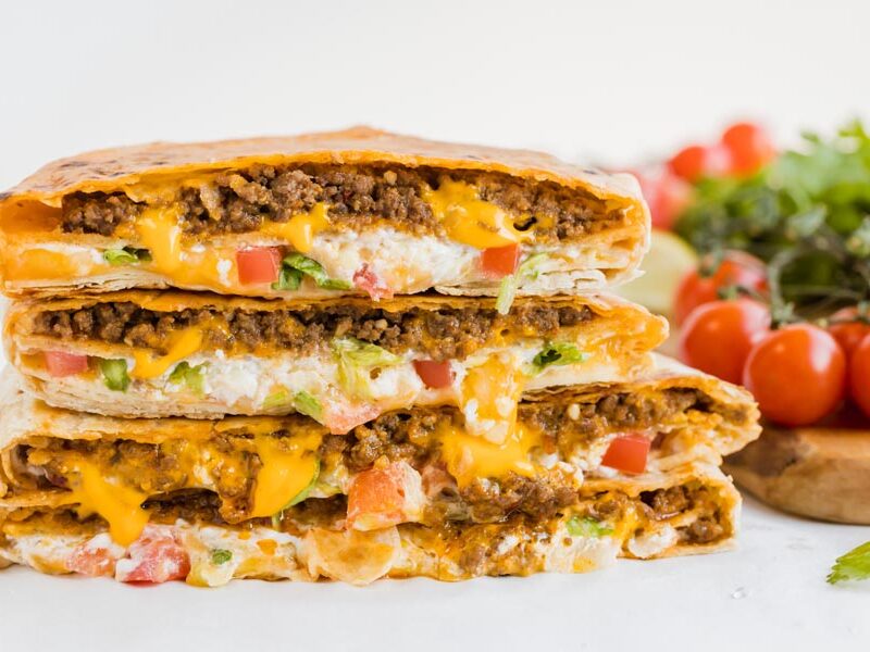 crunch wrap supremes from taco bell with lettuce, tomato, beef and cheese stacked up