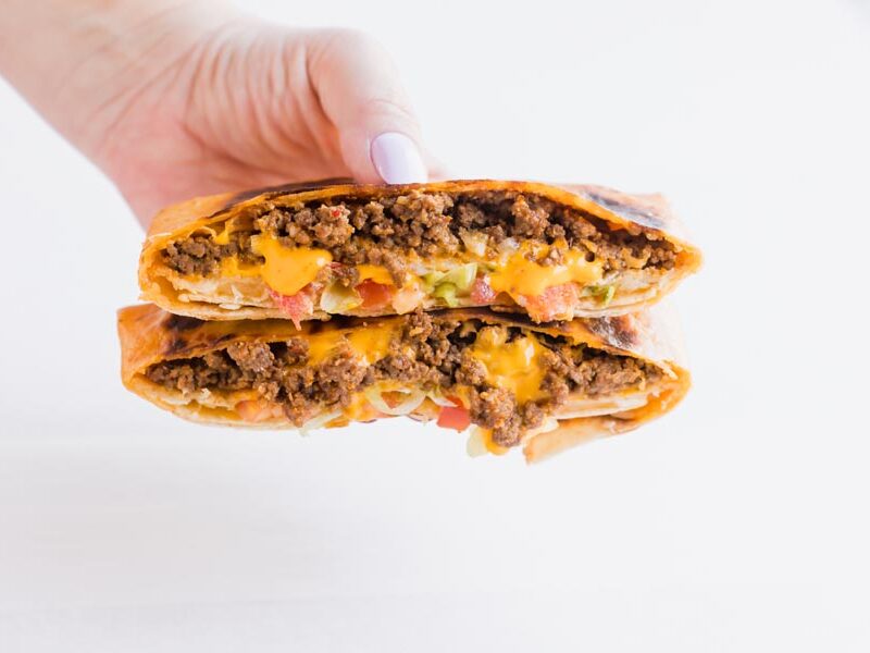 hand holding a keto crunch wrap with beef and melted cheese
