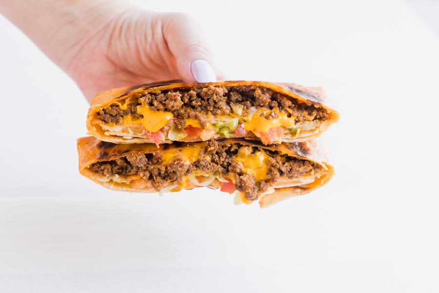 hand holding a keto crunch wrap with beef and melted cheese