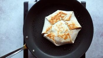 a crunch wrap cooking in a skillet