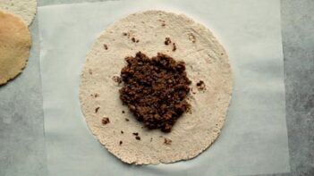 seasoned ground beef on top of a large tortilla