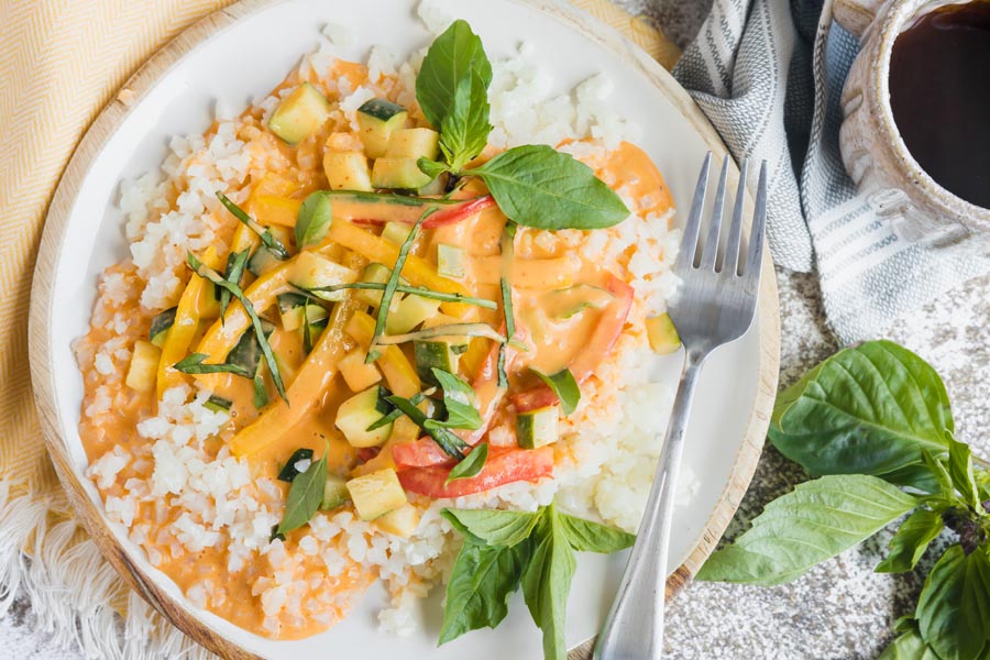 curried vegetables over rice and topped with sliced basil leaves