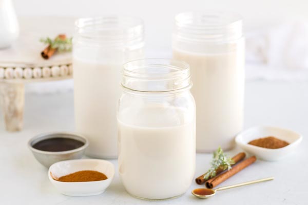 three mason jars containing nut milks