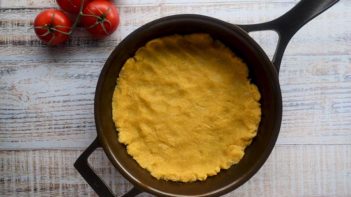 lupin flour pizza crust pressed into a cast iron skillet