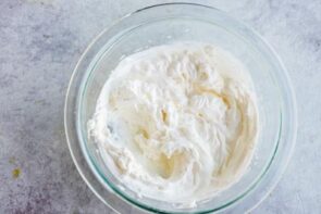 a clear bowl with fluffy whipped cream inside