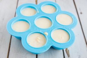 egg mixture inside each hole of a silicone mold sitting on a wooden board