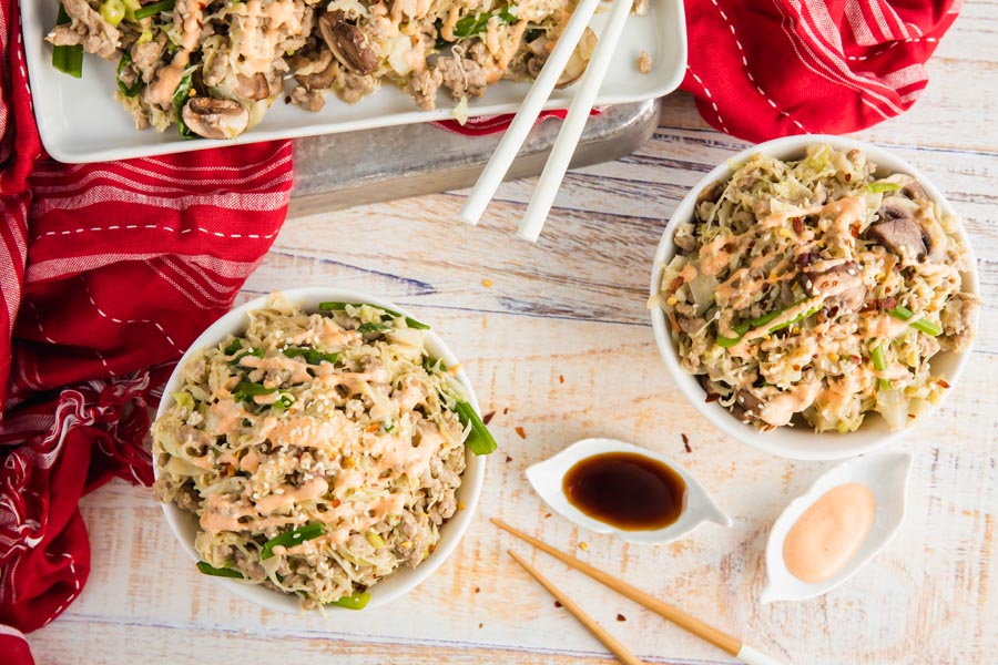 overhead shot of two egg roll in a bowl dishes and a plate with more on it