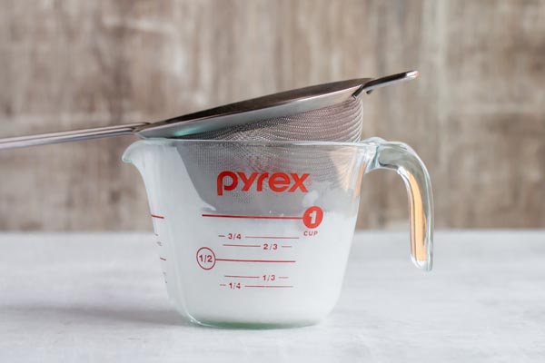 strainer over a measuring cup