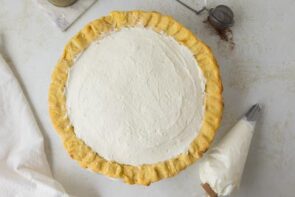 The finished keto eggnog pie topped with a smooth layer of whipped cream ready for garnish.