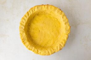 Rolled keto pie crust pressed into a pie dish and docked with fork holes.