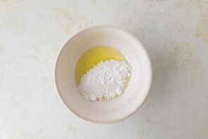 A bowl of ingredients for the eggnog filling with sweetener added to melted butter.